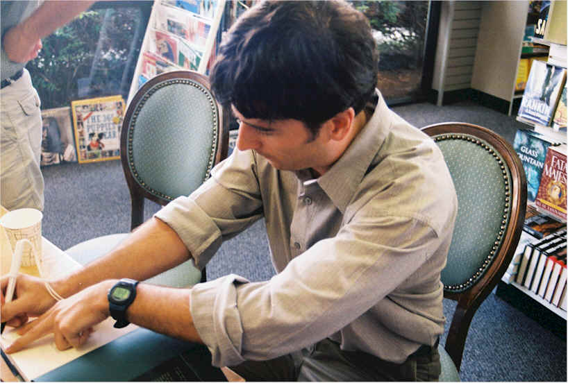 John signing a book for a customer.
